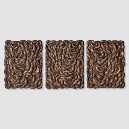 series of three rectangular wall mounted panels created from stacked interwoven black clay rings each mirroring the previous with gold glaze pooled in the ridges and crevices